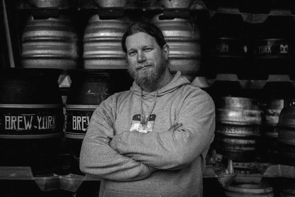 Photo of Lee Grabham in front of Brew York casks